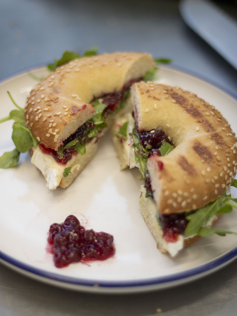 Gegrillter Bagel mit Frischkäse, Rucola und Preiselbeeren im NENNA